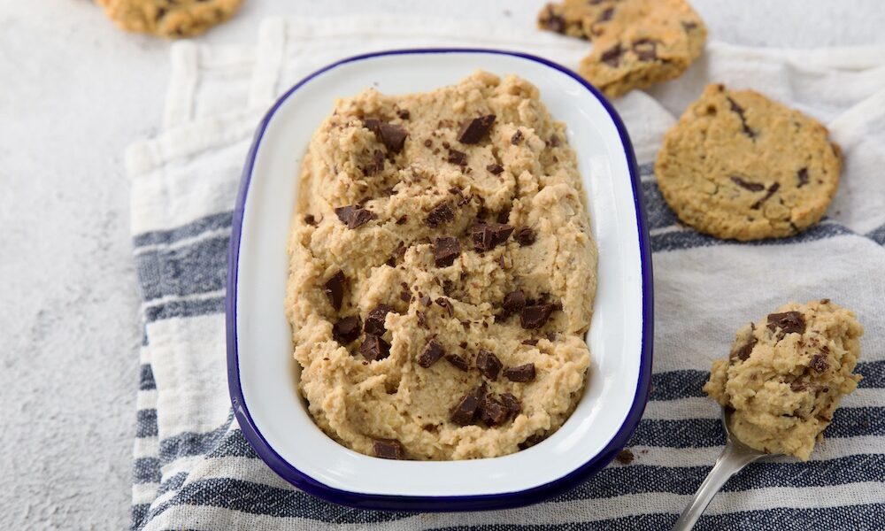 chickpea cookie dough in a enamel dish and few baked cookies on the right