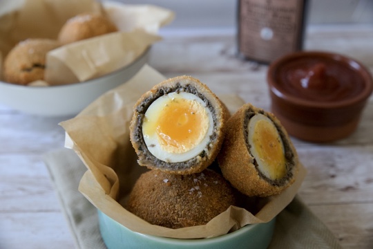 stack of vegetarian scotch eggs, one ope to show the inside
