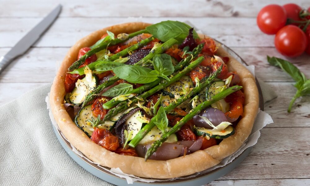 vegetable summer tart with asparagus and fresh basil leaves